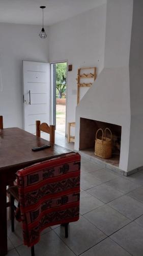 a living room with a table and a fireplace at Cabaña Yerba Buena in Carpintería