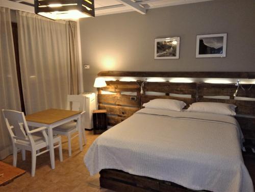 a bedroom with a large bed and a table at Ca'Luna in Mondovì