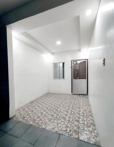 a room with white walls and a tile floor at SNOW Apartment - Near Clark International Airport and Dinosaurs Island in Mabalacat
