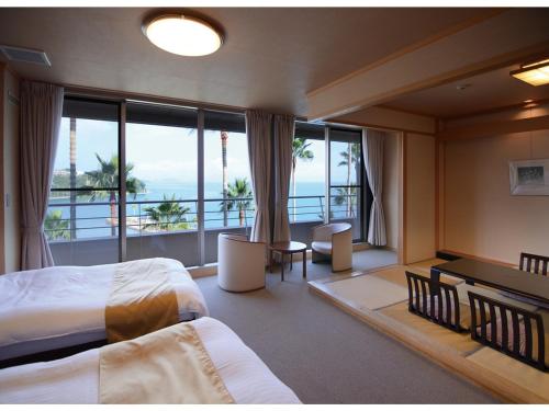 Habitación de hotel con cama y balcón en Hotel Alegria Gardens Amakusa - Vacation STAY 40451v, en Amakusa