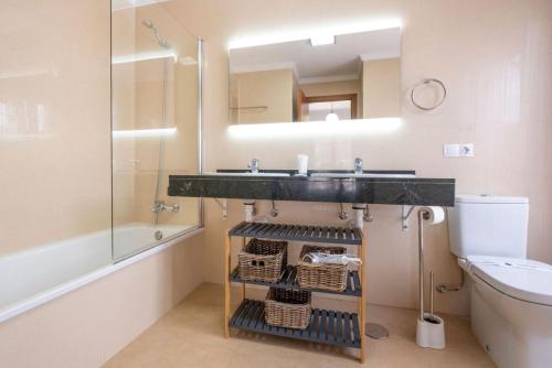 een badkamer met een wastafel en een spiegel bij Casa Familia in Playa Blanca