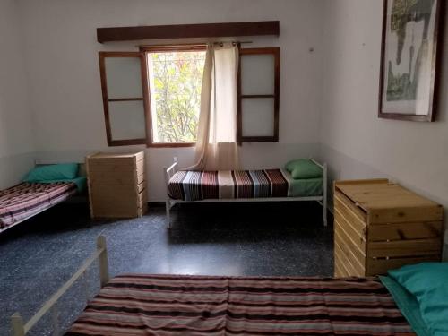 聖薩爾瓦多德胡胡伊的住宿－HOSTEL LA ESPAÑOLA，客房设有两张床和窗户。