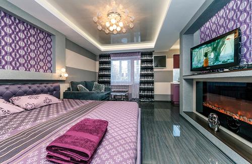 een slaapkamer met een bed en een tv en een bank bij Hotrent Bessarabka Arena in Kiev