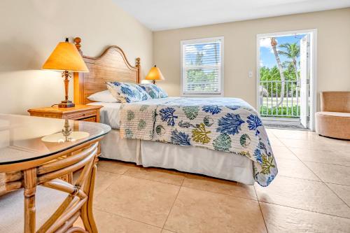 a bedroom with a bed and a desk and a table at Bonefish Bay Motel in Marathon