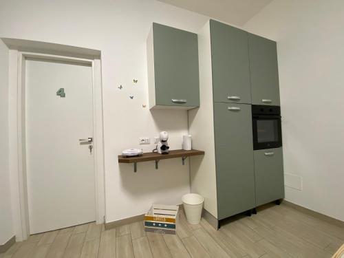 a kitchen with a green cabinet and a door at Le casette di Frà Host and Go in Santa Severa