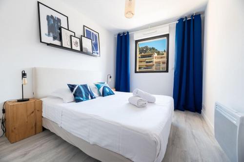 a bedroom with a large bed with blue curtains at Appartement cosy au centre ville de Menton in Menton