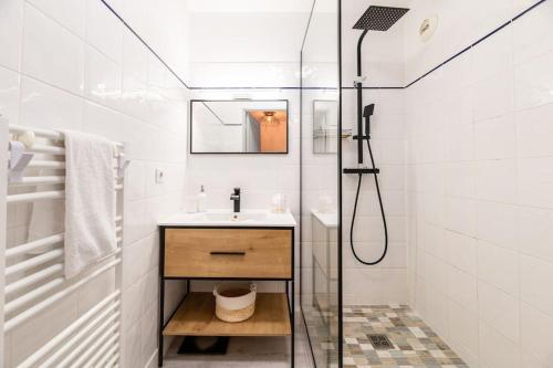 a white bathroom with a sink and a shower at Appartement cosy au centre ville de Menton in Menton