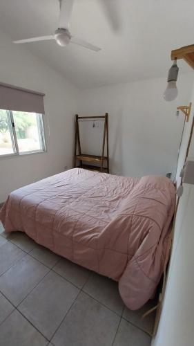 un letto in una camera bianca con un letto ad angolo di Cabaña Yerba Buena a Carpintería