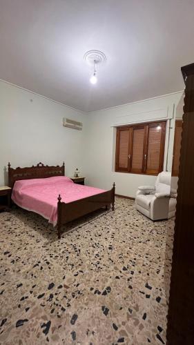 1 dormitorio con 1 cama rosa y 1 silla en Casa Corona - Appartamento affitto breve/lungo termine - casa vacanze, en Terralba