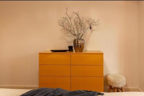 a yellow dresser with a vase on top of it at Downtown Oasis Unirii Apartment in Bucharest