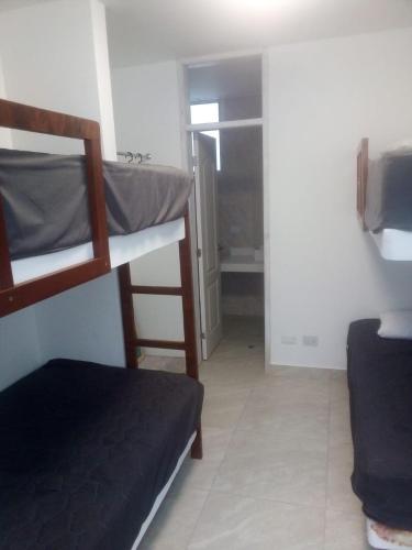 ein kleines Zimmer mit 2 Etagenbetten und einem Badezimmer. in der Unterkunft CONDOMINIO MORAVIA 2 33 in Bujama Baja