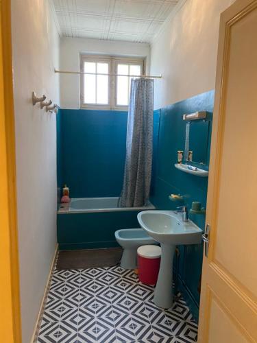 une salle de bain bleue avec des toilettes et un lavabo dans l'établissement Charming little single storey house of 80 metre carre, à La Rochelle
