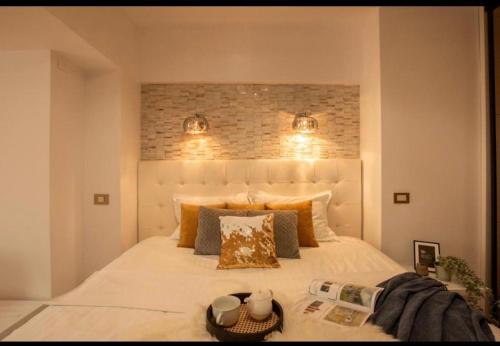 a bedroom with a large white bed with two lights at Downtown Oasis Unirii Apartment in Bucharest