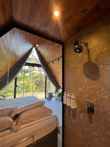 a room with a bed and a glass wall at Pousada Cabanas Araxá in Urubici