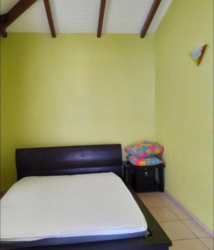 - une chambre avec un lit et une chaise dans l'établissement Superbe villa, à Bouillante