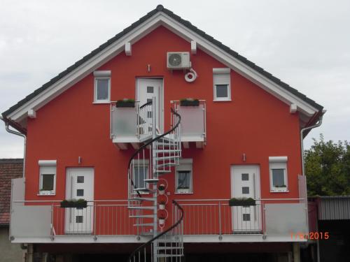 a red house with a spiral staircase in front of it at Ferienwohnung Misita in Rust