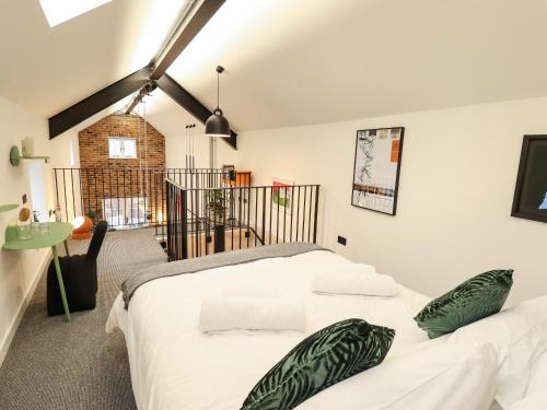 una camera da letto con un grande letto bianco con cuscini verdi di The Pump House Forge a Doncaster