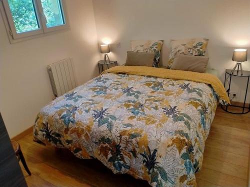 1 dormitorio con 1 cama con un edredón colorido en Gîte à la ferme, en Questembert