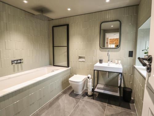 een badkamer met een bad, een toilet en een wastafel bij The Pump House Forge in Doncaster