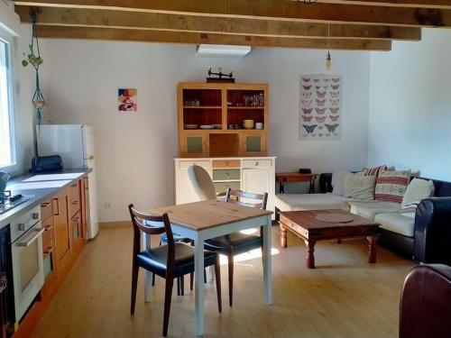 cocina y sala de estar con mesa y sofá en Gîte à la ferme, en Questembert