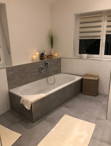 a bath tub in a bathroom with a window at ZENTRALO in Aschaffenburg