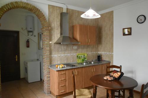 cocina con mesa, fregadero y fogones en Apartamentos Los Gaitanes, en Ardales