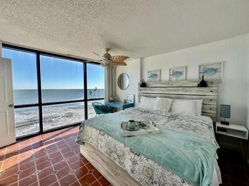 beautiful oceanfront two bedroom condo في دايتونا بيتش: غرفة نوم مع سرير وإطلالة على المحيط