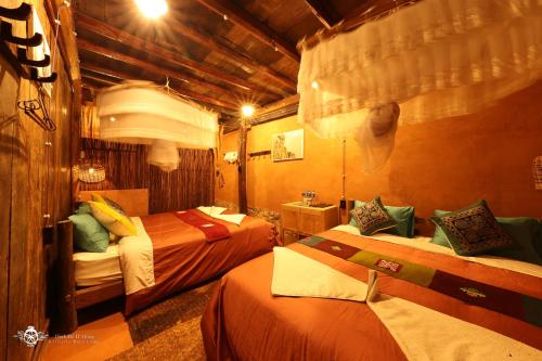 a hotel room with two beds in a room at Dinh Đá H'Mông - Karsterly Rock Lodge in Dồng Văn