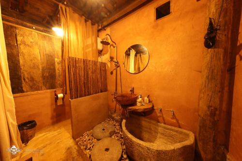 a bathroom with a large tub and a sink at Dinh Đá H'Mông - Karsterly Rock Lodge in Dồng Văn