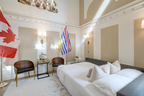 a bedroom with a bed and a desk and flags at Victoria's Parliamentary Suite with Private Rooftop Patio & Harbour View in Victoria