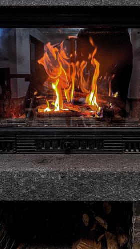 a fireplace with a fire inside of it at Chalet Deluț in Suceava