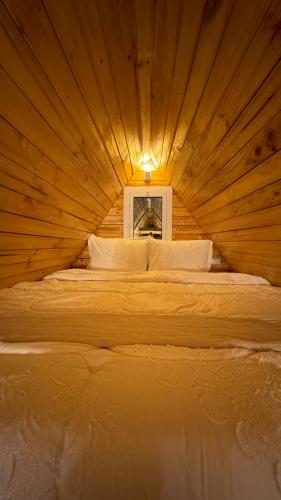 a bed in a wooden room with a window at Marbella bungalows desert in Bidiyah