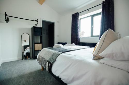 Un dormitorio con una cama grande y una ventana grande. en Ingleborough Lodge, en Settle