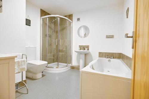uma casa de banho com uma banheira, um WC e um lavatório. em Penyghent View em Rathmell