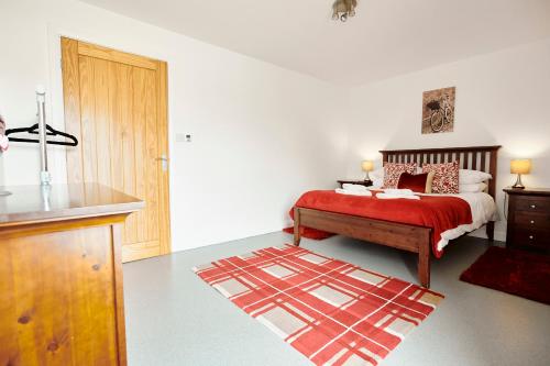 um quarto com uma cama com um cobertor vermelho em Penyghent View em Rathmell