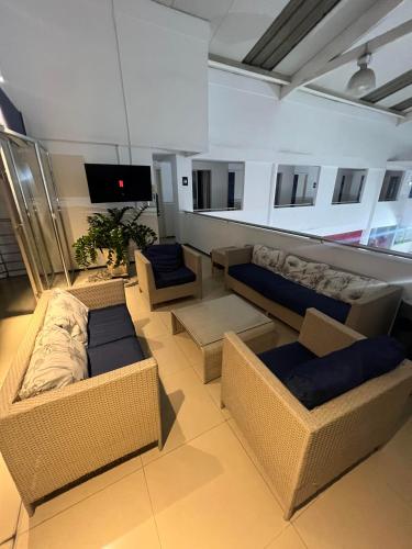 a living room with couches and a flat screen tv at Hotel Boutique Santa Ana in Cartago