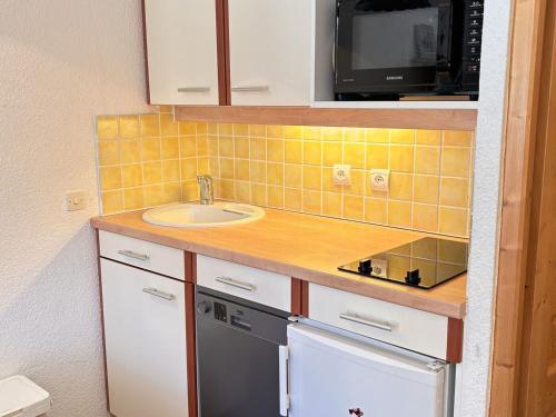 une petite cuisine avec un évier et un micro-ondes dans l'établissement Studio cabine 4 pers. avec balcon et wifi à Avoriaz - FR-1-634-95, à Morzine