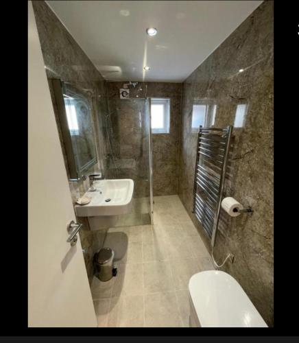 a bathroom with a sink and a shower and a toilet at Anelli Hotel in Southport