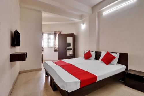 een slaapkamer met een groot bed met rode kussens bij OYO Flagship 81553 Green Residency in Bangalore