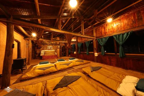 a large room with two large beds in it at Dinh Đá H'Mông - Karsterly Rock Lodge in Dồng Văn