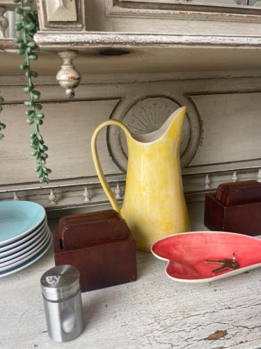 a yellow pitcher sitting on a table next to plates at Cozy Coleman in Hartbeespoort