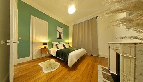 - une chambre avec un lit et un mur vert dans l'établissement Appartement tout équipé - Centre-ville EPERNAY, à Épernay