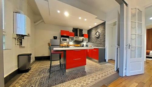 a kitchen with red cabinets and a red counter top at Appartement tout équipé - Centre-ville EPERNAY in Épernay
