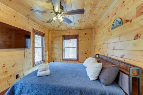 a bedroom with a bed in a log cabin at Forested Ellijay Cabin Rental with Private Hot Tub! in Ellijay