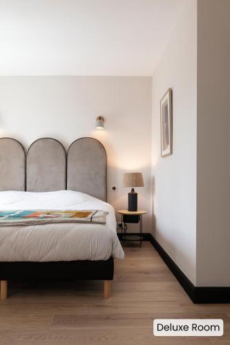 a bedroom with a large bed and a table at Hôtel l'Arena in Fréjus