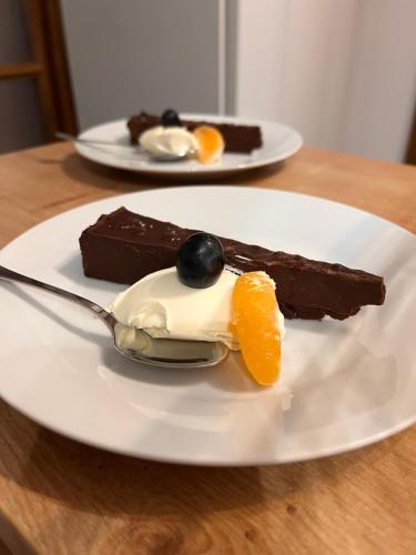a white plate with a piece of chocolate dessert with a spoon at Chalet Deluț in Suceava