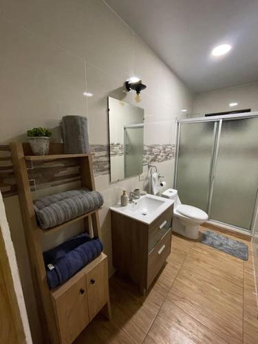 a bathroom with a shower and a sink and a toilet at Lomeli’s Home, Majahual Beach in La Libertad