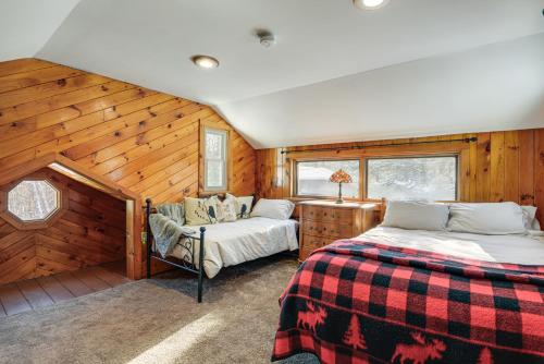 2 Betten in einem Zimmer mit Holzwänden in der Unterkunft Cozy Cabin Between Stratton Resort and Mount Snow in Stratton