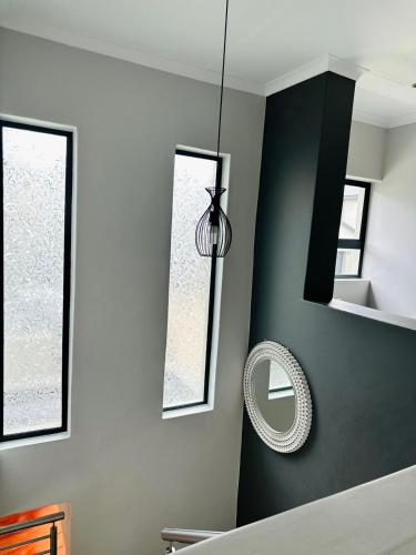 a room with a mirror and a pendant light at Feel at Home Mbombela Self Catering in Nelspruit