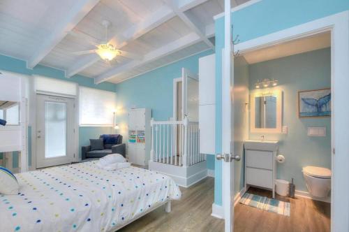 een blauwe slaapkamer met een bed en een bank bij Just Like Paradise in Oak Island